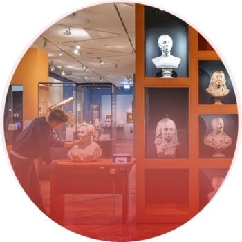 Shelf and table displaying several busts in the German Historical Museum, with a young visitor observing one of the busts closely